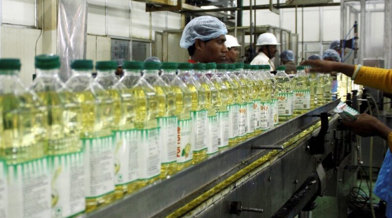Employees fill plastic bottles with edible oil at an oil refinery plant of Adani Wilmar Ltd, a leading edible oil maker, in Mundra, 375 km (233 miles) from the western Indian city of Ahmedabad, June 10, 2009.