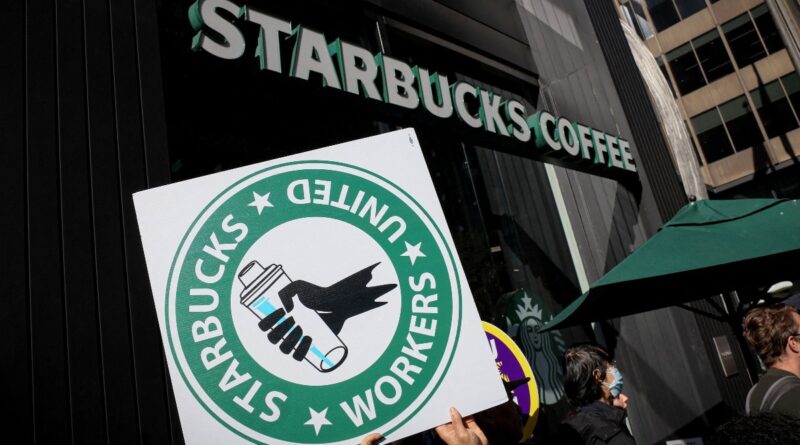 File photo shows members of the Starbucks Workers Union and other labor organization picket and hold a rally outside a company owned Starbucks store in New York City.